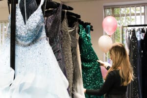Girl looking at different coloured prom dresses at EMA Training for their annual Derby Prom Fair.
