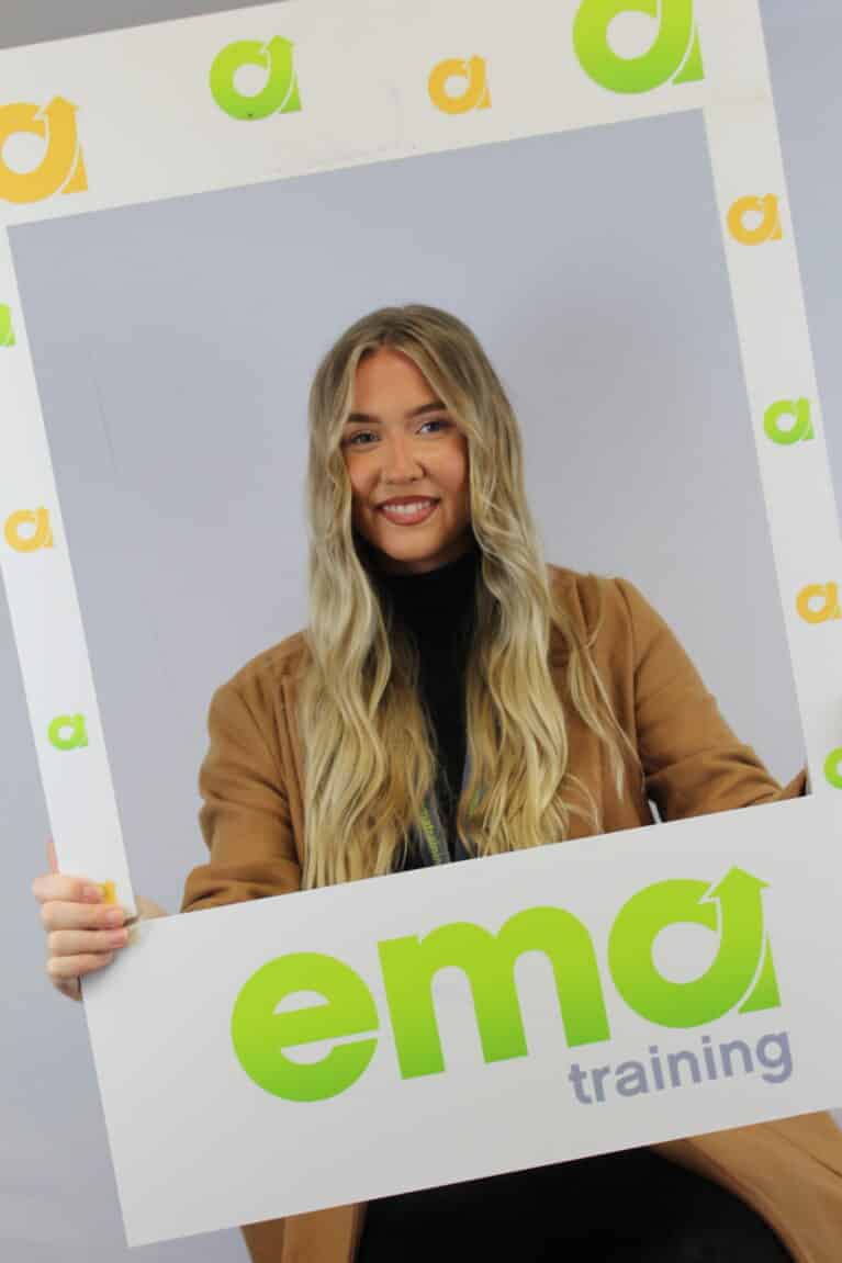 Amy, payroll trainer, holding EMA branded photo frame