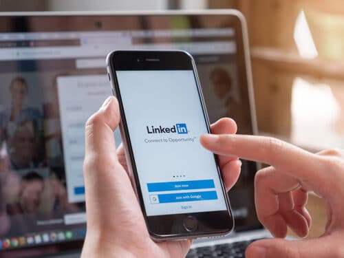 Picture of LinkedIn logo on a phone and how it can help you with building your professional career