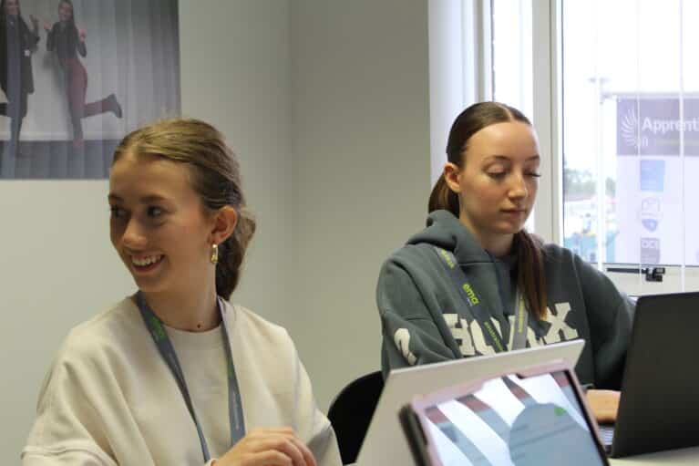 Two Level 4 Marketing Executive Apprentices, Lucy (left) and Jess (right) working at the project table in EMA's Digital Training Hub in Derby City Centre