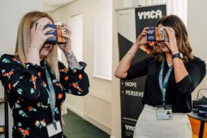 EMA Training Ltd and The Inspirational Learning Group Collaboration. EMA staff Lottie and Caitley looking through virtual reality headsets.