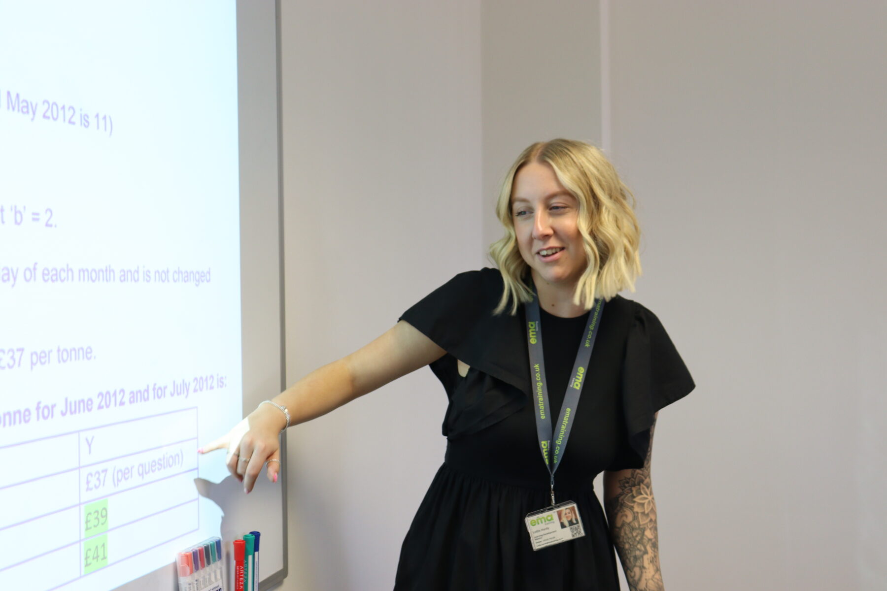 EMA's Accountancy Trainer and Mentor, Lottie, pointing at board