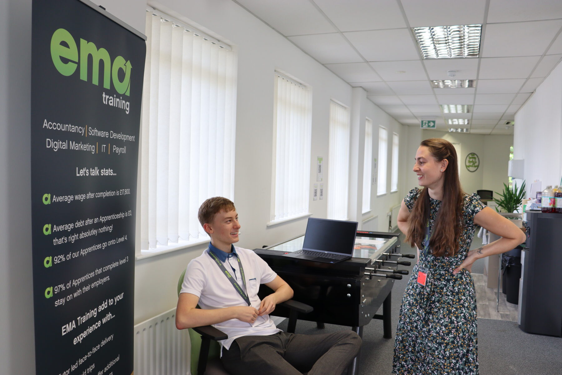 Two members of EMA staff chatting on the top floor of trhe Digital Training Hub. This picture was taken during the 2022 IT & Digital Careers Fair.