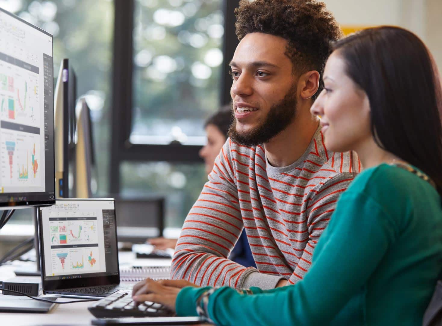 Man and women looking at data on a screen