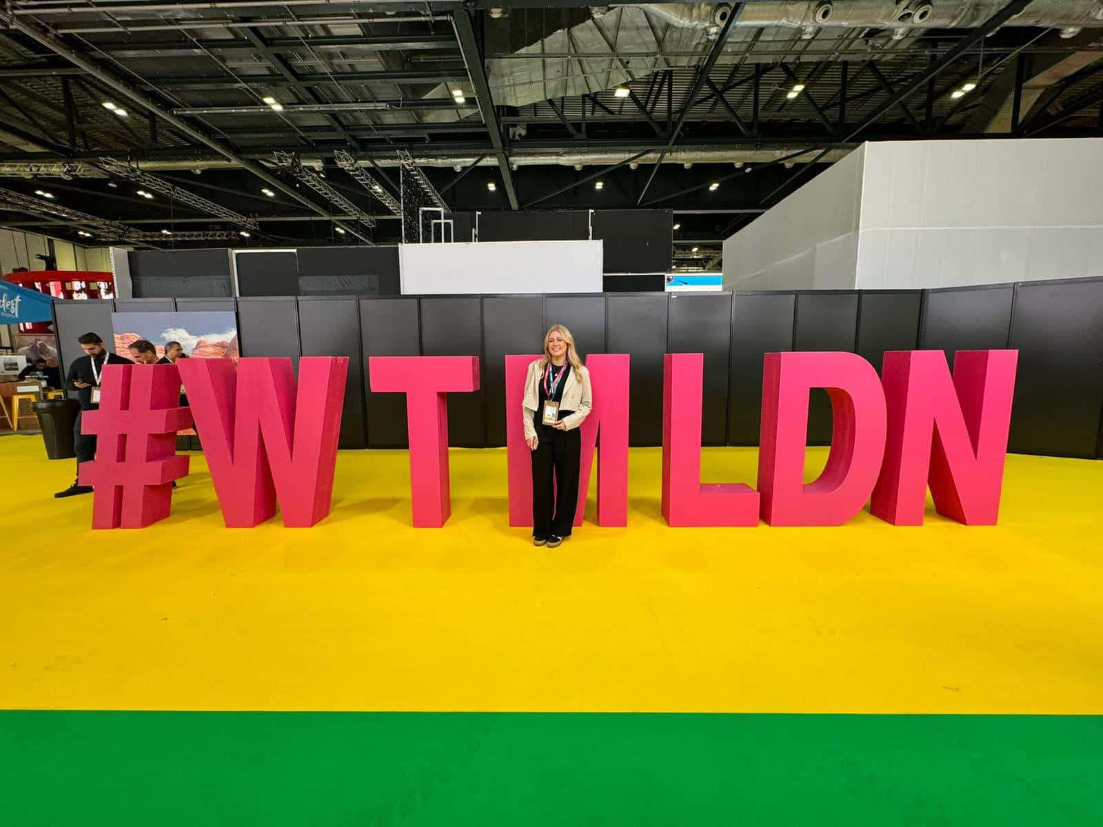 Jess-Scott-standing-in-front-of-a-sign-at-an-expo