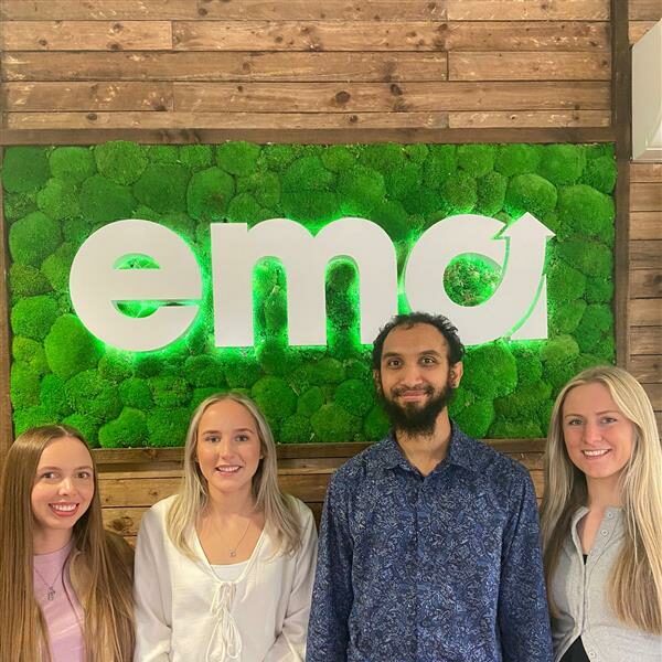Photo of ACCA leaners with a trainer in front of a green EMA sign