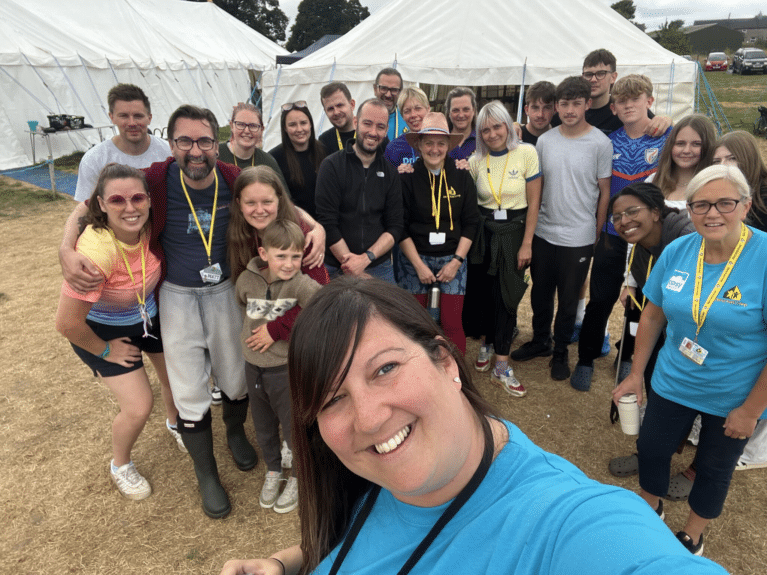Group selfie with Tracey in the foreground and Derby Kids Camp team in the background